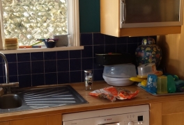 Sink area cluttered and wall units imposed on the space