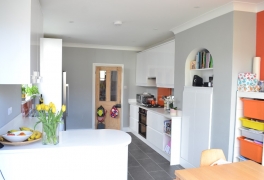 Striking orange feature wall matches offsets grey walls and matches splashbacks